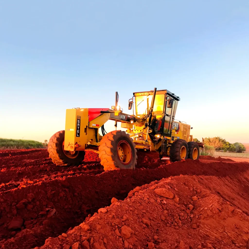 Operador de máquinas pesadas trabalhando com uma motoniveladora Caterpillar